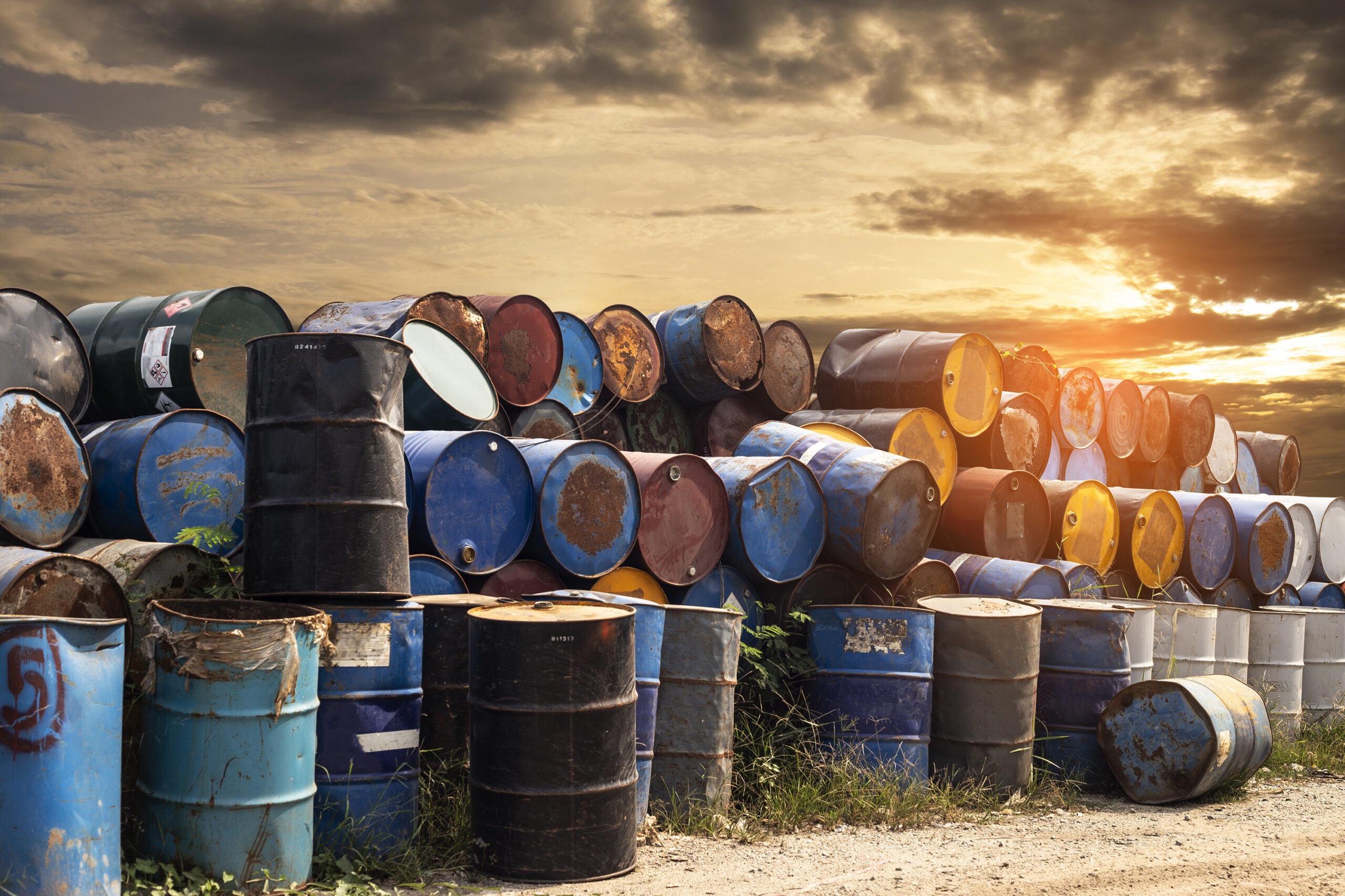 Old metal chemical tanks at sunset sky, dirty oil steel drums, environment, chemical disposal